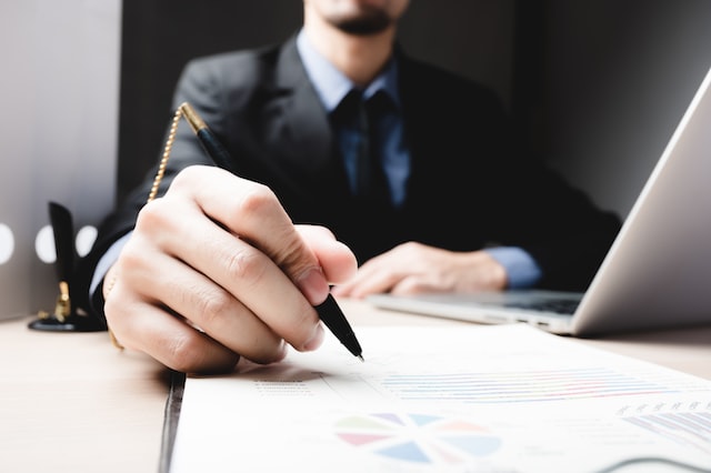 person writing on business documents